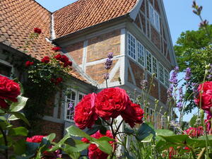 Dies ist en Foto vom Kr&uuml;gerschen Haus in Geesthacht, im dem sich die Tourist-Information und das GeesthachtMuseum befinden, mit Blumen im Vordergrund.