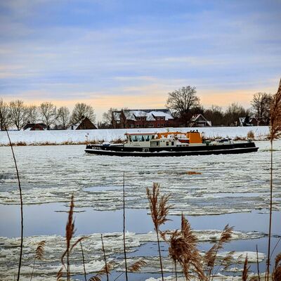 Bild vergr&ouml;&szlig;ern: Symbolbild zum Winter - Eisbrecher f&auml;hrt auf dem zugefrorenen Fluss Elbe mit Eisplatten vor dem Dorf Tespe im Winter