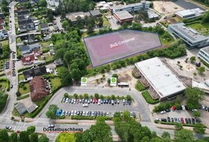 Bild vergr&ouml;&szlig;ern: Luftaufnahme eines Schulgel&auml;ndes am D&uuml;sselbuschberg mit eingezeichneten Markierungen f&uuml;r ein Verkehrskonzept. Eine gro&szlig;e, r&ouml;tlich schraffierte Fl&auml;che im Zentrum ist als &raquo;BvS-Container&laquo; markiert. Im Vordergrund befindet sich ein Parkplatz mit zwei Bushaltestellen-Symbolen. Ein Pfeil am linken Rand weist auf den &raquo;Schulweg&laquo; hin, der in ein angrenzendes Wohngebiet f&uuml;hrt.