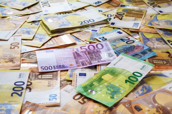 Ein ungeordneter, dichter Haufen von Euro-Geldscheinen in verschiedenen Nennwerten. Im Fokus liegen ein violetter 500-Euro-Schein im Zentrum und ein gr&uuml;ner 100-Euro-Schein im Vordergrund, umgeben von zahlreichen 50-, 200- und einzelnen 20-Euro-Scheinen.