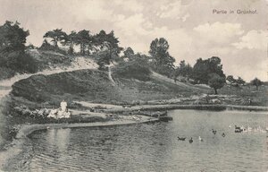 Eine historische, schwarz-wei&szlig;e Postkarte im Querformat, die als Mehrbildkarte gestaltet ist und drei verschiedene Ansichten zeigt. Die Bilder sind durch geschwungene, helle Linien und dezente florale Ornamente voneinander getrennt.

Obere linke Ansicht: Zeigt eine unbefestigte Dorfstra&szlig;e, an deren rechtem Rand ein gro&szlig;es, zweist&ouml;ckiges Geb&auml;ude mit hellem Putz und dunklem Dach steht. Davor ist ein h&ouml;lzerner Gartenzaun zu sehen. Am linken Stra&szlig;enrand stehen Telegrafenmasten. Unter dem Bild steht in feiner, dunkler Schrift &raquo;Gruss aus Gr&uuml;nhof&laquo; sowie darunter kleiner &raquo;Gasthof von H. Schaper&laquo;.

Obere rechte Ansicht: Zeigt ein langes, einst&ouml;ckiges reetgedecktes Fachwerkhaus mit einem tiefgezogenen Dach, das von hohen, belaubten B&auml;umen umgeben ist. Davor erstreckt sich eine weite, unbefestigte Fl&auml;che.

Untere, &uuml;ber die gesamte Breite gehende Ansicht: Zeigt ein gro&szlig;es, herrschaftliches Anwesen oder Hotelgeb&auml;ude inmitten einer park&auml;hnlichen Anlage mit dichten Baumkronen. Das Geb&auml;ude besitzt ein helles Erdgeschoss und ein dunkel gestaltetes Fachwerk-Obergeschoss mit mehreren Dachgauben. Am unteren Bildrand ist die Beschriftung &raquo;Etablissement Waldfrieden&laquo; zu lesen.