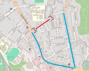 Ein Ausschnitt einer Stra&szlig;enkarte zeigt eine gesperrte Stra&szlig;e. Die Sperrung ist rot markiert und durch Absperrgitter begrenzt. Eine Umleitung ist blau eingezeichnet. 